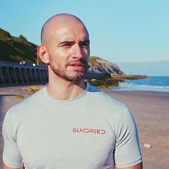 Shaun wearing a Sundried Olperer tshirt at the beach